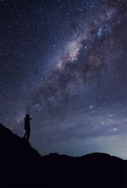 A person is standing next to the Milky Way galaxy thump up on a — Stock Photo, Image
