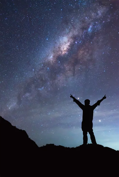 O persoană stă lângă galaxia Calea Lactee întinsă mână în mână — Fotografie, imagine de stoc