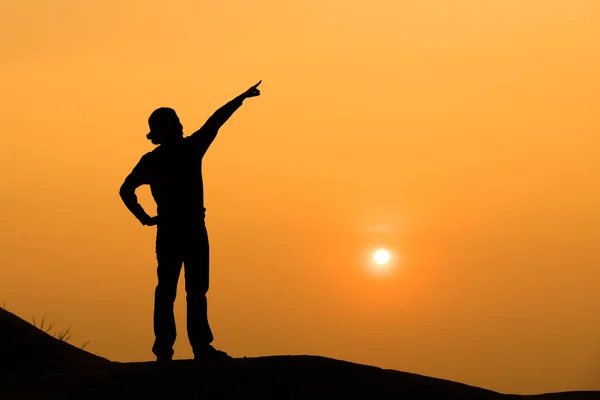 La silhouette di una donna punta la mano verso il cielo — Foto Stock