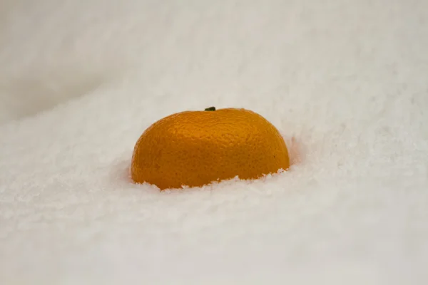 Mandarina naranja en nieve blanca —  Fotos de Stock