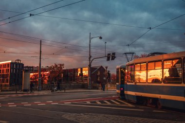 Şehir sokağı gün batımında yayılıyor.