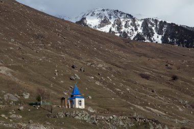 Küçük bir şapel dağlarda mavi çatılı.