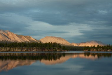 Gün batımı ışık ve onların yansıma göle yaktı dağlar.