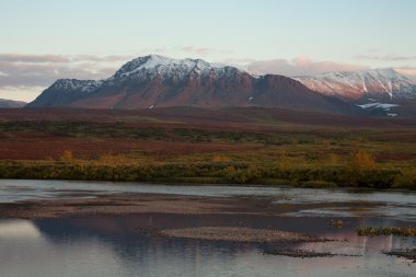 Sakin bir nehir yansıma dağlar.