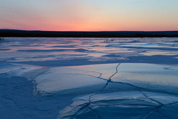 Campo di ghiaccio in crepe e cielo rosso . — Foto Stock