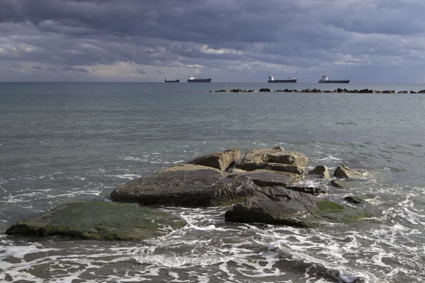 Stones on the shore and ships at sea. — Stock Photo, Image