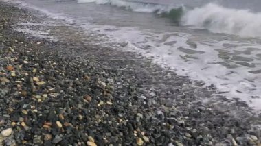 Çakıl plaj dalgalar deniz haddelenmiş.