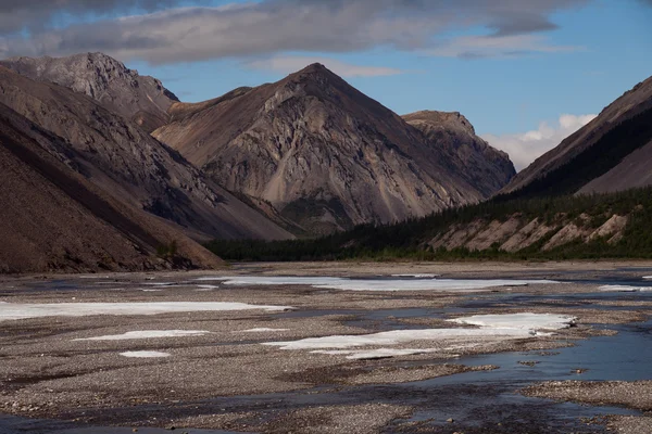 Restos de hielo en el valle de un río de montaña . —  Fotos de Stock