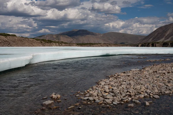 Restos de hielo en el valle de un río de montaña . — Foto de Stock