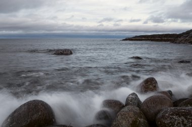 Deniz kıyısı üzerinde yuvarlak taşlar.