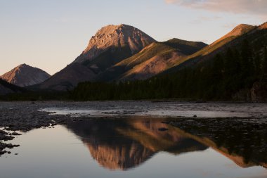 Dağ etkileyici formu ile onun yansıması nehre.