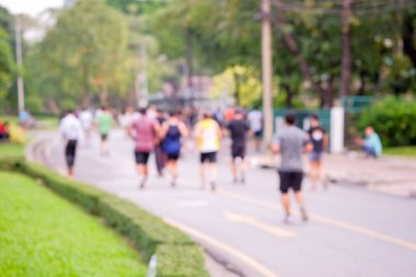 İşten sonra parkta koşan insanların dikiz görüntüsü ve bulanık görüntü odağı, bulanık odak arka planında koşmak sağlığın etkinliklerinden biridir.