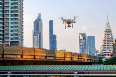 Akşam saatlerinde Bangkok 'ta araştırma yapmak için üstte uçan orta büyüklükte bir kuadkopter.
