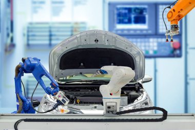 Endüstriyel robotik ekip çalışması otomobille çalışıyor. Bulanık mavi renk arka plan, insan yerine robot işi, endüstri 4.0 ve yapay zeka konsepti.