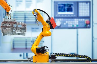 Hareket eden kaynak robotu ve robot sürükleyici motorun motor parçaları ile çalışan bulanık mavi renk arka plan, gelecekte insan yerine robot işi, endüstri 4.0 ve yapay zeka konsepti