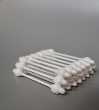 Gri arka planda tıpası olan pamuklu çubuklar. Bir çocuğun kulaklarını temizlemek. Pamuklu çubukları durduruculu yakın plan çek. Çocuk bakımı ve hijyen.