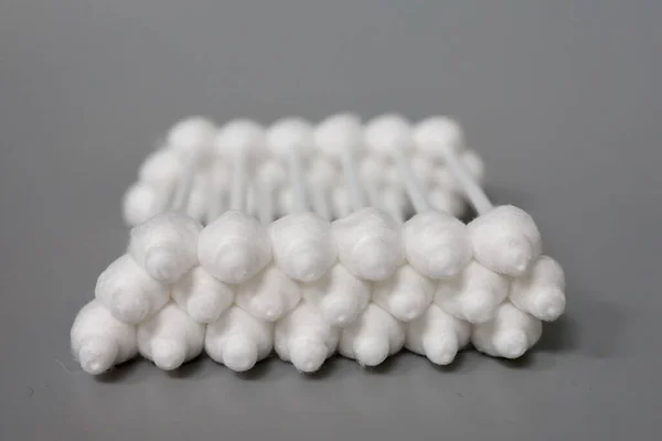 Gri arka planda tıpası olan pamuklu çubuklar. Bir çocuğun kulaklarını temizlemek. Pamuklu çubukları durduruculu yakın plan çek. Çocuk bakımı ve hijyen.