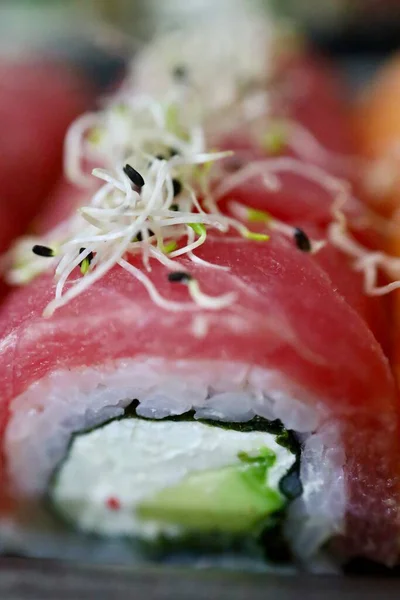 Ton balıklı suşi rulosu, krem peynirli ve mikroyeşillikli, yukarıdan kompozisyon. Makro fotoğraf, yüksek kaliteli fotoğraf..