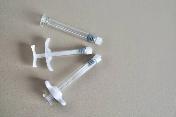 Mezoterapi, biyo-evrizasyon ya da botulinyum tedavisi için üç farklı kullanılmış şırınga. Bej arka planda kullandıktan sonra güzellik enjeksiyonları için şırıngalar. Metin için yer