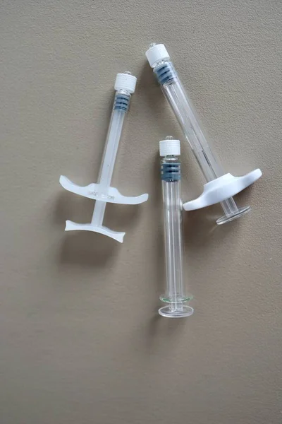 Mezoterapi, biyo-evrizasyon ya da botulinyum tedavisi için üç farklı kullanılmış şırınga. Bej arka planda kullandıktan sonra güzellik enjeksiyonları için şırıngalar. Metin için yer