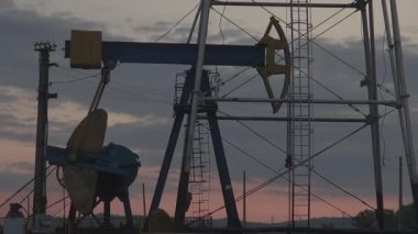 Gün batımında pompalanan petrol kuyuları