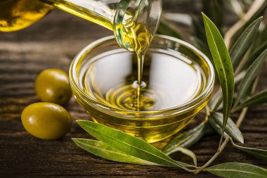 Taze zeytin ve yapraklı cam kaseye zeytinyağı dök.