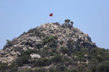 Dağlarda bir kayanın üzerinde Türk bayrağı