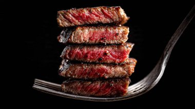Siyah arka planda ızgara biftek ve sos.