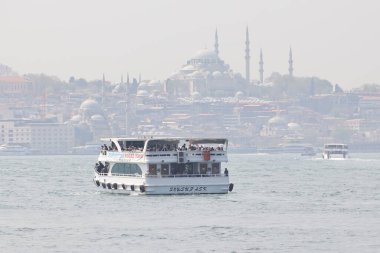 21-01-2025 İstanbul Türkiye: Arka planda tarihi şehir silüeti bulunan İstanbul Boğazı 'nda yolcu feribotu kalkıyor