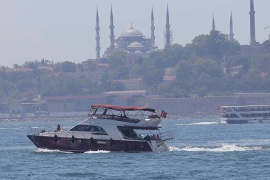 30-05-2024 İstanbul Türkiye: Arka planda cami siluetleri ile Boğaz üzerinde motorlu yat turu