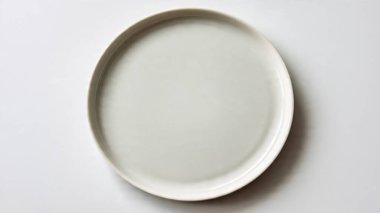 Beyaz zemin üzerinde boş seramik plaka. en üstteki görünüm