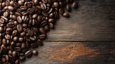Ahşap arka planda kahve çekirdekleri, yazı için yeri olan üst manzara. Kahve çekirdekleri ahşap bir masaya saçılmış.
