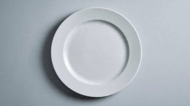 Gri tabakta beyaz seramik tabak.