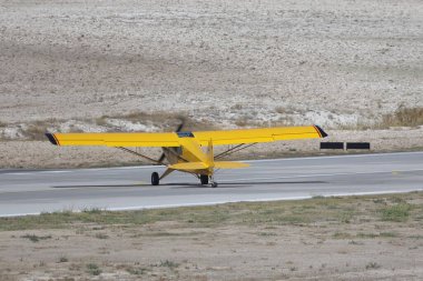 Yollarda uçan sarı bir uçak.