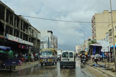 28-08-2025 Dakar Senegal: Arabaları ve dükkanları olan yağmurlu şehir caddesi