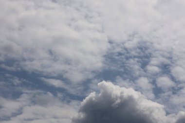 Parlak mavi gökyüzünün altında katmanlı kümülüs bulutları