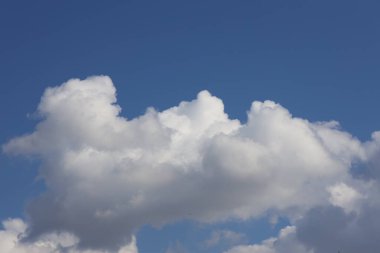 Derin mavi gökyüzüne karşı büyük kabarık bulut oluşumu
