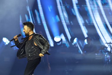 24-01-2026 İstanbul Türkiye: Tarkan mavi konser ışığı altında canlı performans sergiliyor