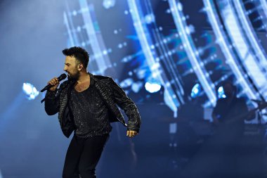 24-01-2026 İstanbul Türkiye: Tarkan mavi konser ışığı altında canlı performans sergiliyor