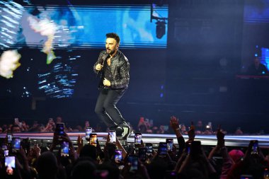 24-01-2026 İstanbul Türkiye: Tarkan mavi konser ışığı altında canlı performans sergiliyor