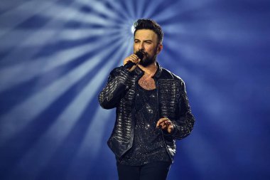 24-01-2026 İstanbul Türkiye: Tarkan mavi konser ışığı altında canlı performans sergiliyor