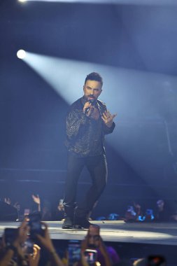 24-01-2026 İstanbul Türkiye: Tarkan mavi konser ışığı altında canlı performans sergiliyor