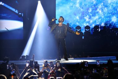 24-01-2026 İstanbul Türkiye: Tarkan mavi konser ışığı altında canlı performans sergiliyor