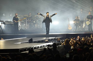 24-01-2026 İstanbul Türkiye: Tarkan mavi konser ışığı altında canlı performans sergiliyor