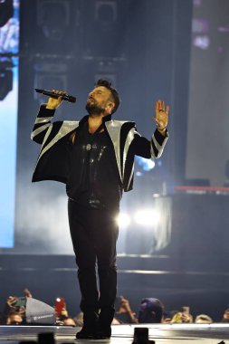24-01-2026 İstanbul Türkiye: Tarkan mavi konser ışığı altında canlı performans sergiliyor