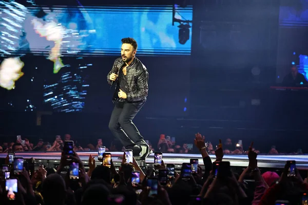 24-01-2026 İstanbul Türkiye: Tarkan mavi konser ışığı altında canlı performans sergiliyor