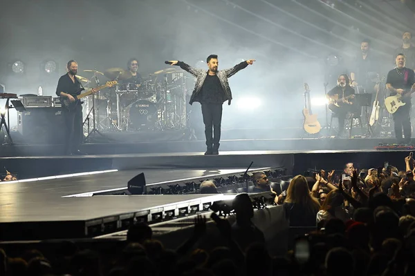 24-01-2026 İstanbul Türkiye: Tarkan mavi konser ışığı altında canlı performans sergiliyor