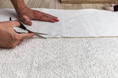 Close up of fitting a white boucl fabric cover on a corner sofa Concept of furniture renovation, upholstery work, and interior design craftsmanship.