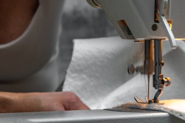 Close up of fitting a white boucl fabric cover on a corner sofa Concept of furniture renovation, upholstery work, and interior design craftsmanship.