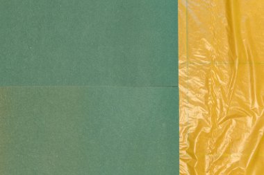 Kaplama veya vinil döşeme tesisatı için hazırlık aşamasındayız. Yeşil koruyucu eldivenlerle çalışan işçilerin elini kapat. Sarı buhar bariyerindeki kullanışlı bir bıçakla yeşil zemin kaplamasını kes.. 